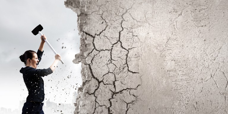 Young attractive businesswoman with hammer in hands